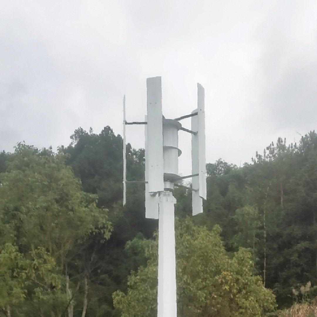 H1000 wind turbine on its mast, blades and assist wheel against the sky