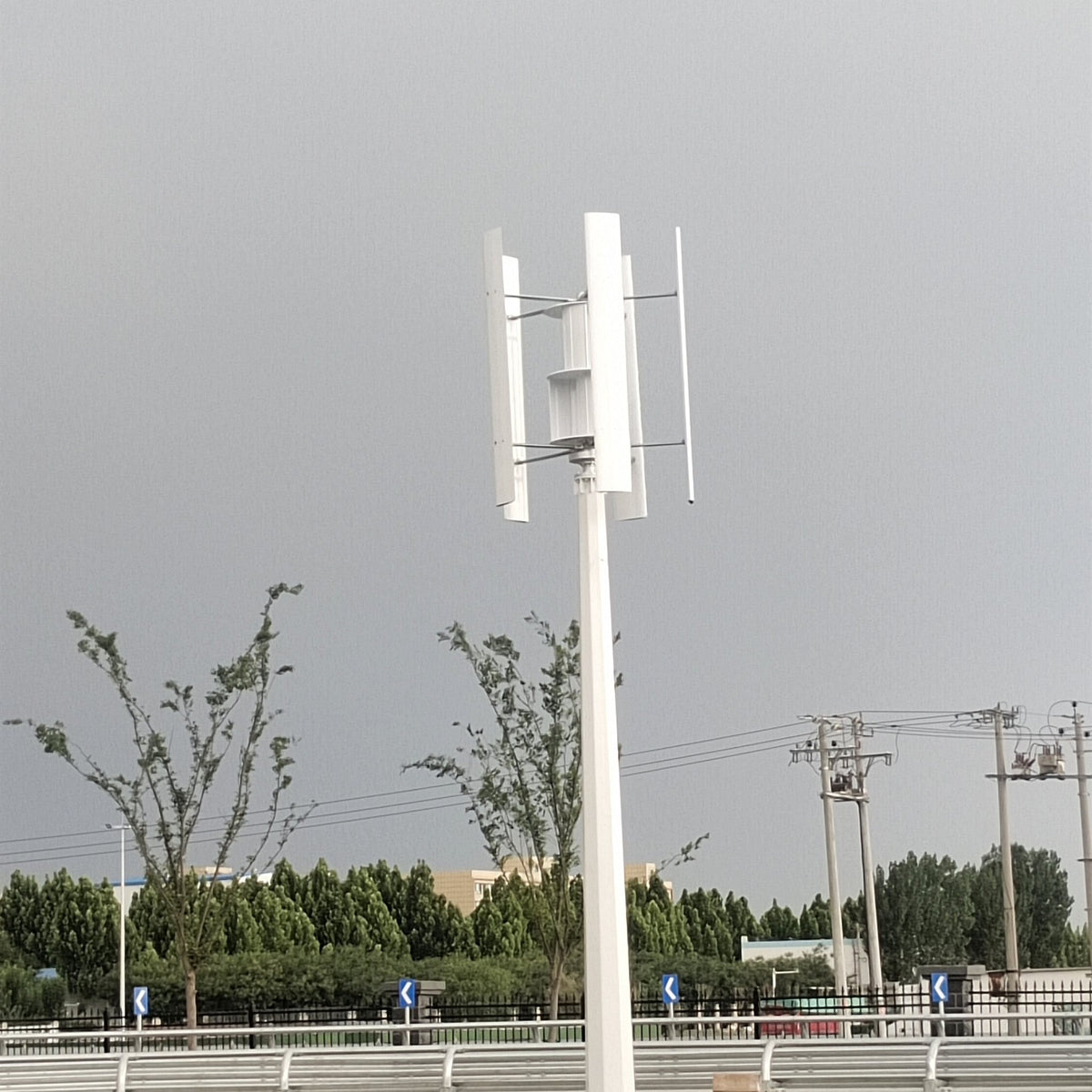 H1000 on a white mast beside a road, with its equipment box at the base