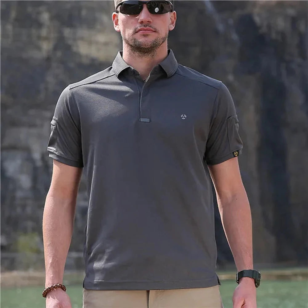Man wearing the grey tactical polo shirt, standing by water