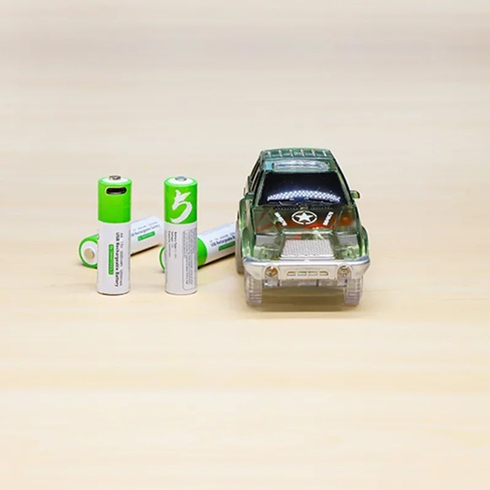 Four AA USB-C rechargeable cells standing beside a toy four-wheel drive on a timber bench