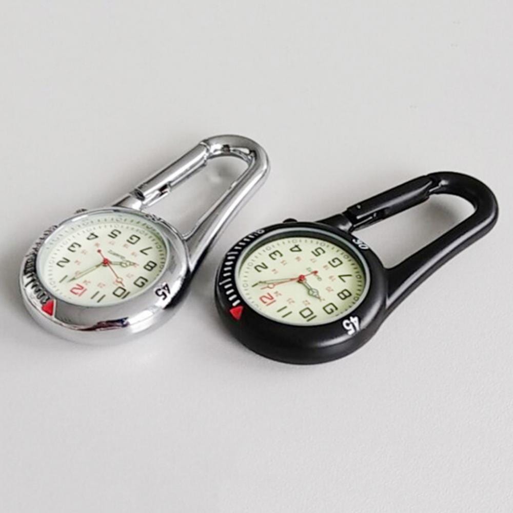 Silver and black carabiner clip watches side by side on a grey surface, luminous dials facing up