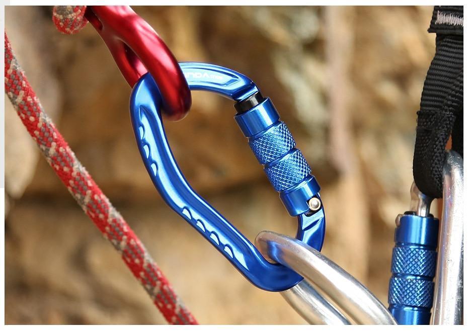 Blue carabiner linked to a red one and a steel ring outdoors