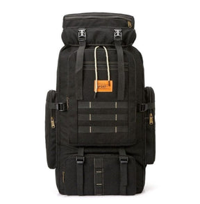 Black canvas pack front on, with leather badge and brass-toned zips