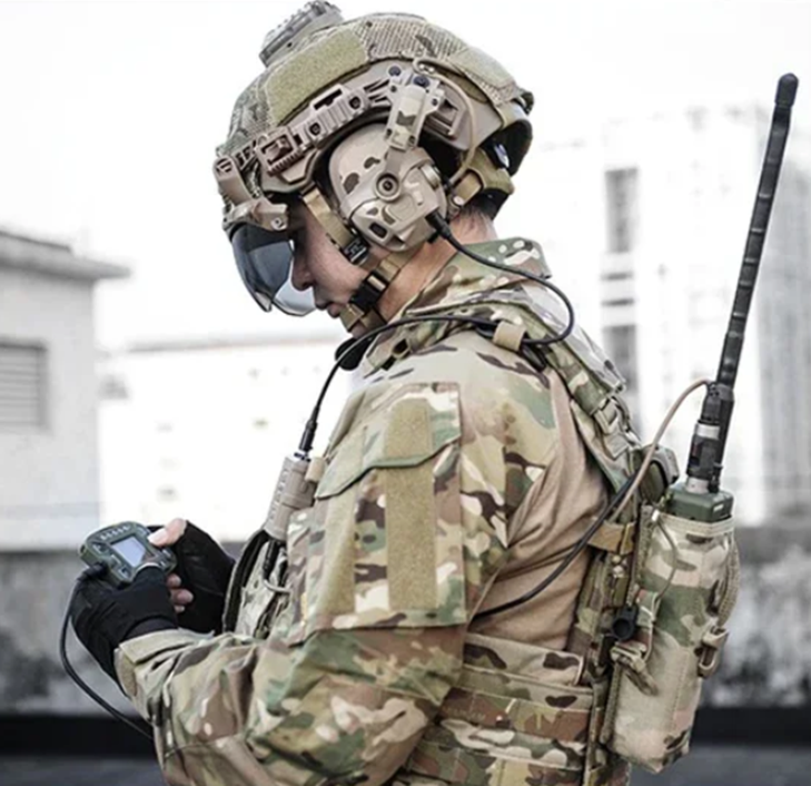 Person in military gear with communication equipment outdoors