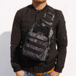 Python black snake-print sling bag worn across the chest over a black jacket