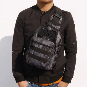 Python black snake-print sling bag worn across the chest over a black jacket