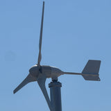 A small horizontal-axis wind turbine with three blades and a tail fin, shown against a clear blue sky.
