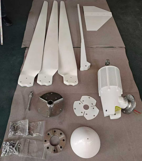 Every part laid out: three white FRP blades, tail boom and vane, generator with mounting flange, hub and clamp plates, nose cone and bagged fixings.