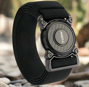 Black belt coiled on river stones, showing the buckle and the strap keeper loop