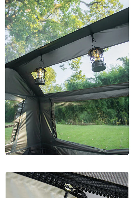 Two lanterns hung from hooks inside the tent, looking out through the open mesh window panels.