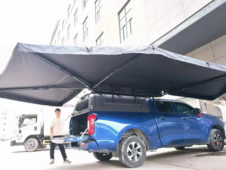 Black 270 degree awning fully deployed over a blue dual-cab ute canopy