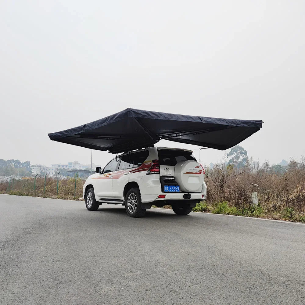 Rear three-quarter view of the black awning wrapping around a white four-wheel drive