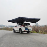Rear three-quarter view of the black awning wrapping around a white four-wheel drive