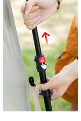Close-up of a hand extending the tent's telescopic pole, with the red release button marked.