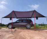 Awning deployed on a dark SUV with red support poles and guy ropes