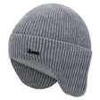 Light grey wool beanie from the side with earflaps down, showing the folded cuff and ribbed crown