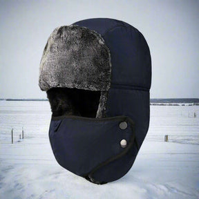 Navy blue trapper hat over a snowy field, ear flap lifted to show the pile lining