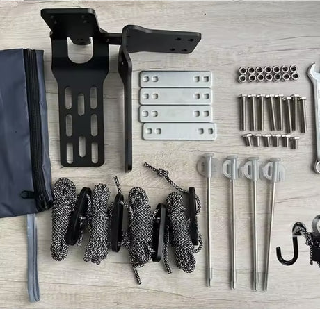 Flat lay of included brackets, plates, bolts, pegs, guy ropes, spanner and pouch