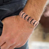 Wide copper link bracelet worn on a man's wrist