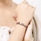 Slim X-link copper bracelet worn on a woman's wrist