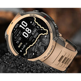 DM59 GPS smartwatch with a gold bezel and sand-coloured silicone strap, set in black gravel