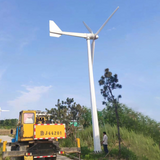 G Type horizontal wind turbine being installed on its ground mast by a crane truck, a person at the base for scale - representative family photo