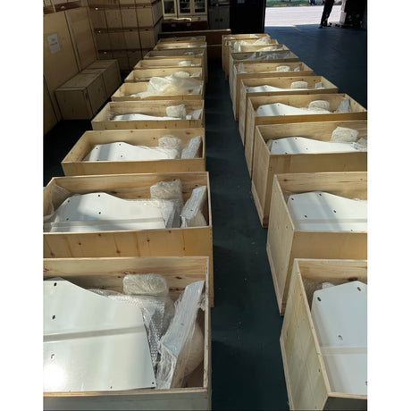 Rows of open plywood crates on the DHC factory floor holding white wind turbine body parts in bubble wrap