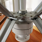 Close-up of the H12 generator housing and bolted blade-arm hub beneath the five-blade rotor - representative family photo