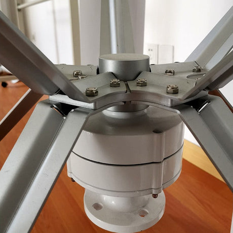 Close-up of the white H12 generator housing and its bolted mounting flange beneath the five-arm aluminium blade hub.