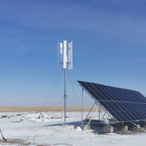 H2000 wind turbine on a guyed mast next to a tilted solar array in winter
