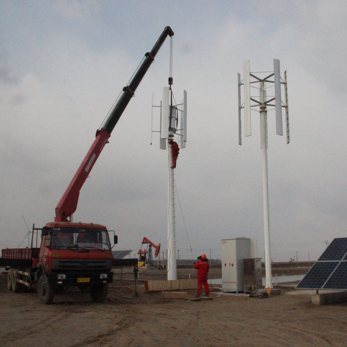 Crane raising an H2000 beside a second installed turbine at a solar site