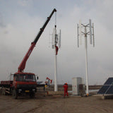 Crane raising an H2000 beside a second installed turbine at a solar site