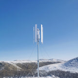 H2000 vertical wind turbine on a guyed mast above snow-covered hills