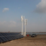 H2000 vertical wind turbines standing over a row of solar panels