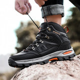 Black hiking boot on a rock while the wearer pulls the laces tight