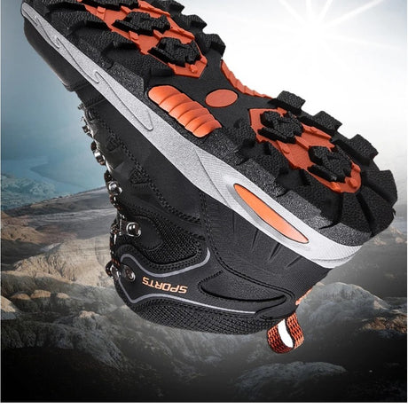 Underside of the black hiking boot showing the deep rubber lug pattern and orange inserts