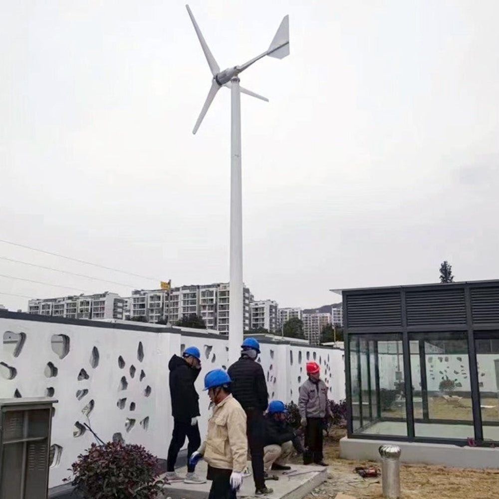Installation crew in hard hats raising a horizontal-axis wind turbine on a tall mast — representative L-series family photo