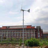 Horizontal-axis wind turbine installed on a tall guyed mast in front of a large building — representative L-series family photo