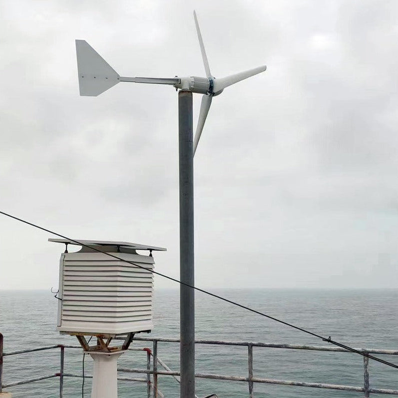 L-series wind turbine pole-mounted next to a weather station enclosure overlooking the sea - representative family photo