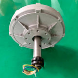 Silver generator face-on, showing the bolt-hole flange around the shaft and the ribbed aluminium case
