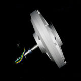 Side view of the silver generator on a black background, showing the flat disc-shaped case and the shaft with leads