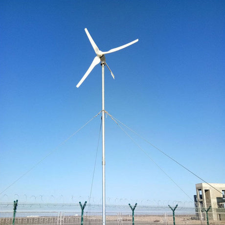 M-series horizontal-axis turbine on a guyed mast in open country under a blue sky - representative family photo