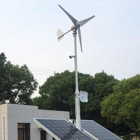 M-series turbine above two solar panels on a rooftop pole mount with CCTV camera and antennas - a wind-solar hybrid setup
