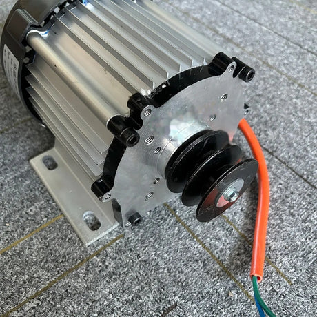Close view of the twin-groove belt pulley on the generator shaft, with the slotted foot base below