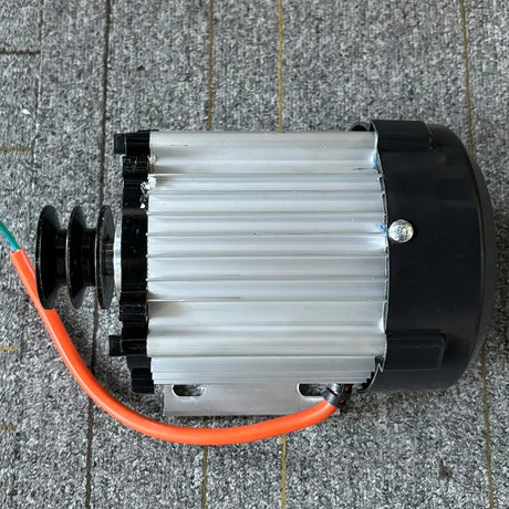 Side view of the generator head showing the finned case, the bolt-down foot and the orange output cable