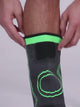 Grey knitted knee sleeve with green trim pulled on over the knee, then its two straps crossed over the front and fastened.