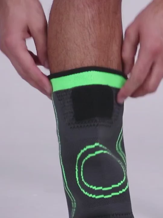Grey knitted knee sleeve with green trim pulled on over the knee, then its two straps crossed over the front and fastened.