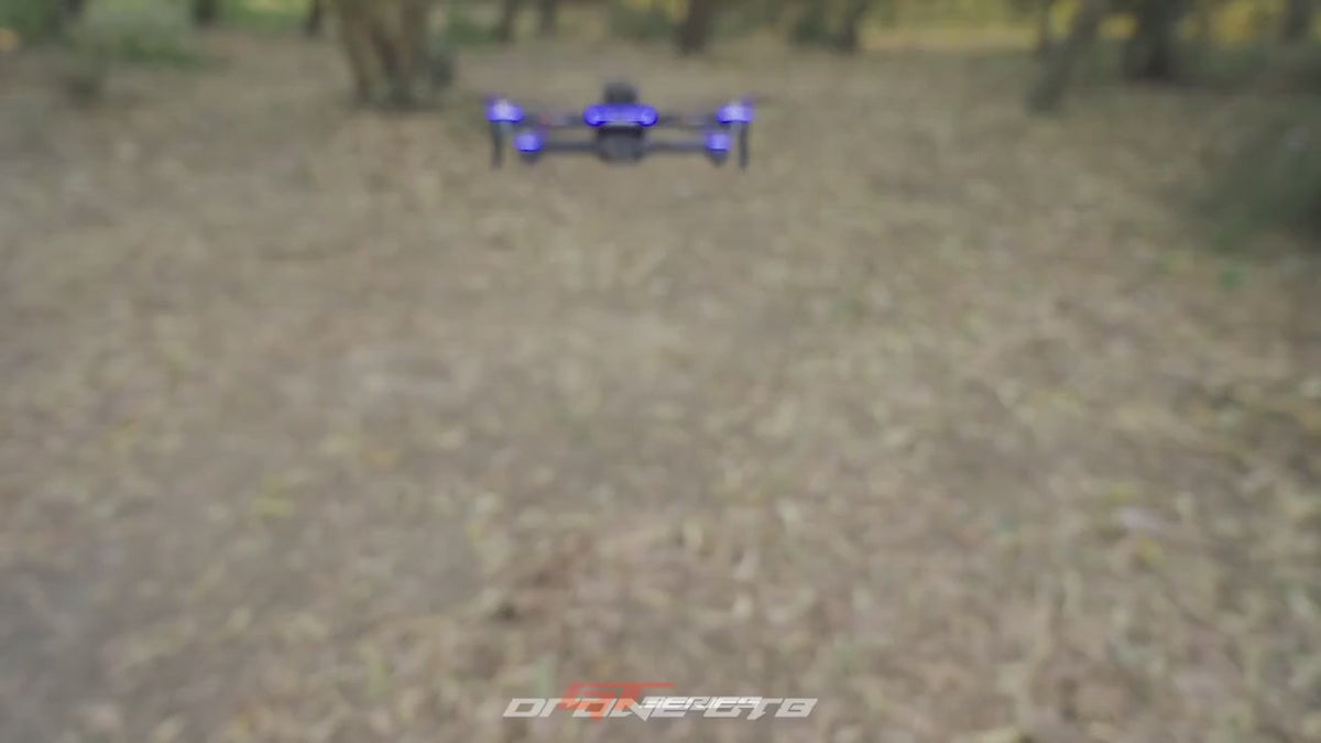 GT8 drone flying towards the camera; close-ups of a brushless motor, the camera and the screen remote; the view from its front and downward cameras; the remote's screen showing the live picture; the drone holding a low hover and stopping short of a tree; ending with it landing on an open hand.