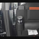 The black seat-back organiser on a car seat with a bottle, tumbler and tissues, then hung over the front seat, strapped under the bottom edge and filled with a tablet, phone and drinks.