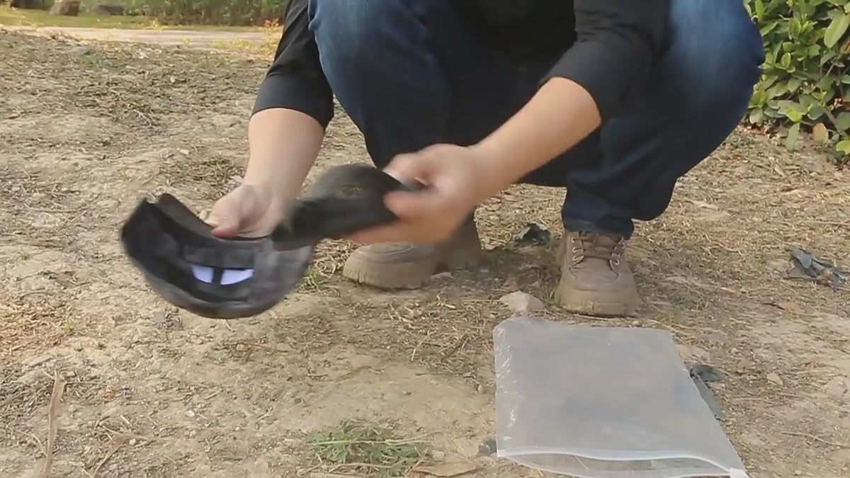 The folding mesh mask and camo cap laid out on the ground after unpacking, then the mask fitted to the cap by hand.